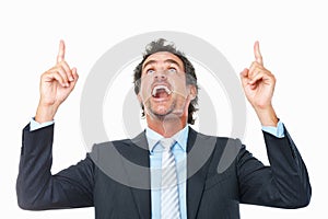 Business man looking and pointing upwards. Happy surprised business man looking and pointing upwards against white