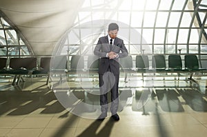 Business man looking at watch on his arm in the airport