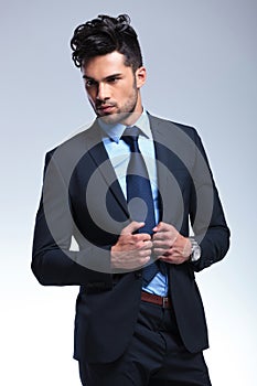 Business man looks away while holding his lapels photo