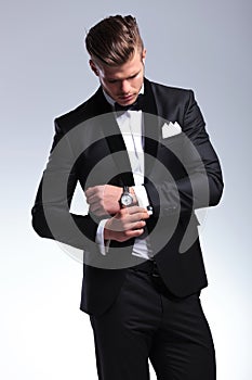 Business man looks at his cufflinks photo