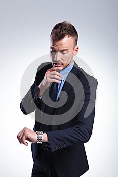 Business man looks at watch