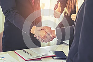 Business man with handshake with partner and woman cheering