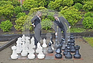 Business man making chess move in garden