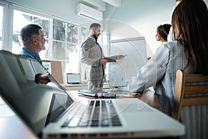 Business man making a presentation at office. Business executive delivering a presentation to his colleagues