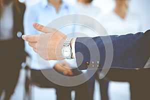 Business man making presentation to group of people, close-up. Speaker delivering a seminar to his colleagues or