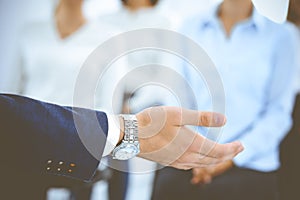 Business man making presentation to group of people, close-up. Speaker delivering a seminar to his colleagues or