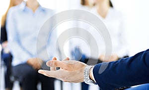 Business man making presentation to group of people. Speaker delivering a seminar to his colleagues or business training