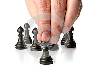 Business man moving chess figure in front of other chess figures