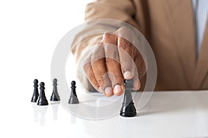 Business man moving chess figure with team behind - strategy or