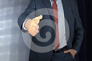 A business man with an open hand extended to handshake