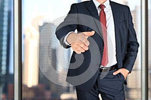 A business man with an open hand extended to handshake