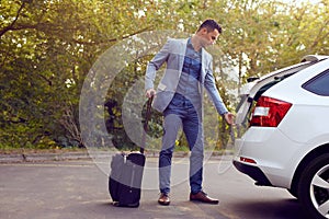 Business man opens car trunk