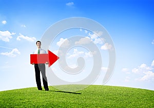 Business Man Outdoors Holding an Arrow Pointing Copy Space