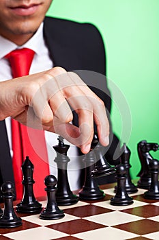 Business man playing chess black makes first move