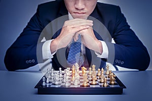 Business man is playing chess, business management strategy concept