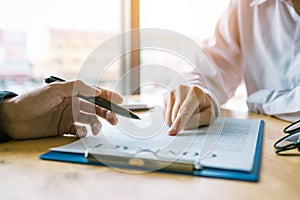 Business man pointing on contract paper to customer reading cont