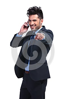 Business man pointing finger while talking on smartphone