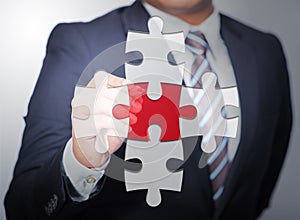 Business Man pointing on red jigsaw