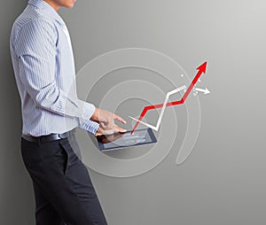 Business man pointing tablet with increasing arrow graph