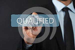 Business man pointing the text: Qualified