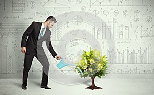 Business man pouring water on lightbulb growing tree