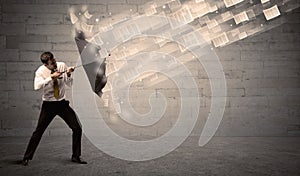 Business man protecting with umbrella against wind of papers