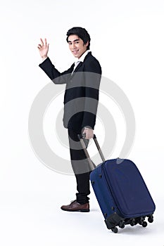 A business man pulling luggage and waving hand