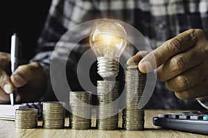 Business man putting a coin on coins stack saving bank and account for his money all in finance accounting concept