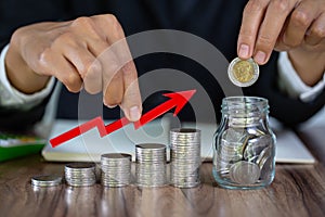 Business man putting coin in glass bottle saving bank and account for his money all in finance accounting, account and saving