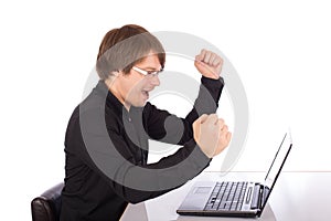 Business man raises arms in front of his laptop