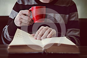 Business man reading book with coffee in coffee shop.