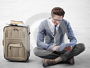 Business man, reading or luggage with tablet, floor and smile with app, flight or travel by wall background