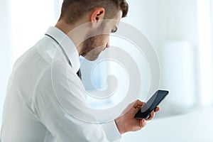 Business Man Reading Something on the Screen of His Cell Phone