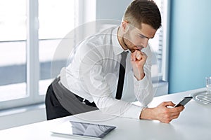 Business Man Reading Something on the Screen of His Cell Phone