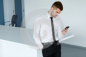 Business Man Reading Something on the Screen of His Cell Phone