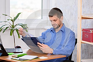 Business man reads a printed report in a folder