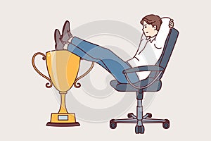 Business man received leadership cup sits in office chair, demonstrating disdain for colleagues