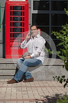 Business man on red classic English telephone box