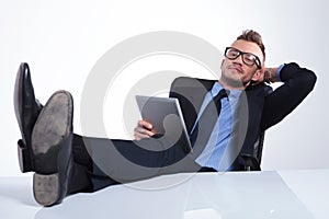 Business man relaxes with tablet in hand