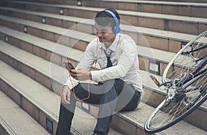 Business man relaxing listening to music with his bicycle on