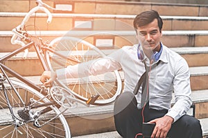 Business man relaxing listening to music with his bicycle on