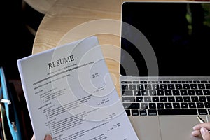 Business man review his resume application on desk, laptop computer, job seeker