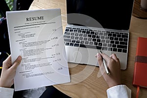 Business man review his resume application on desk, laptop computer, job seeker