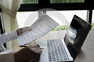 Business man review his resume application on desk, laptop computer, job seeker