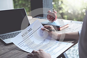 Business man review his resume application on desk, laptop computer, job seeker