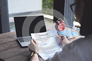 Business man review his resume application on desk, laptop computer, job seeker