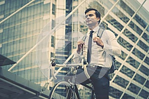 Business man riding his bicycle to work in a modern city