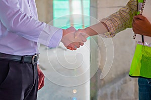 Business man is shaking hand with his operator after meeting in building site