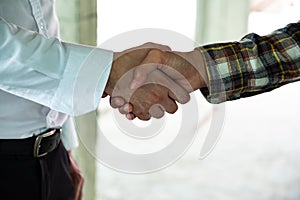 Business man is shaking hand with his operator after meeting in building site