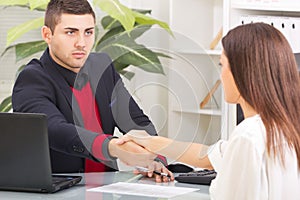 Business man shaking hands with a client after signing the cont